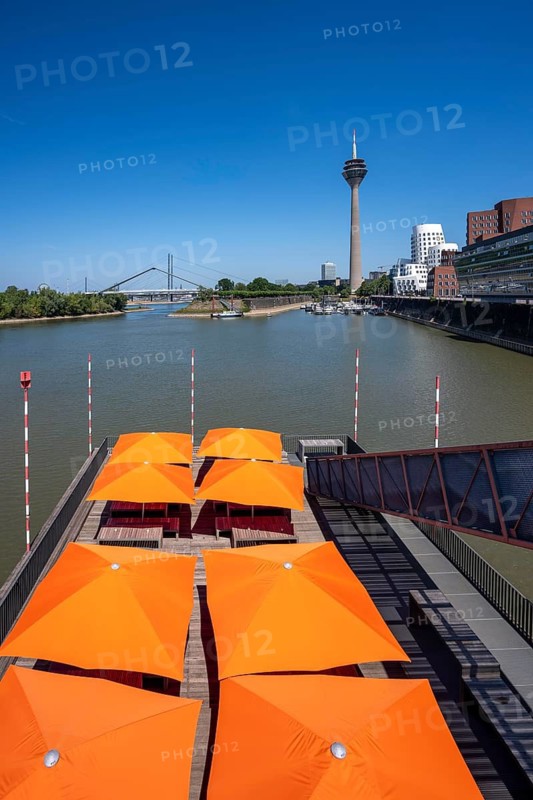 Building in the media harbor in Düsseldorf, terrace of the Lido-Hafen Restaurant, Neuer Zollhof, Gehry buildings, Rhine Tower, modern residential and office buildings, as well as old port buildings, various industries, lots of catering, creative industries, fashion, media, advertising, North Rhine-Westphalia, Germany