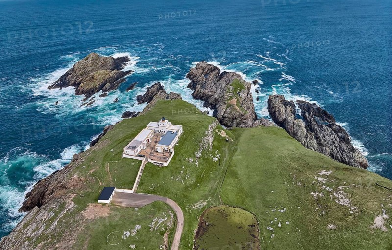 Aerial drone photo of Iighthouse on the rocky cliffs and heavy atlantic ocean surf, Strathy point, northern Scotland, UK