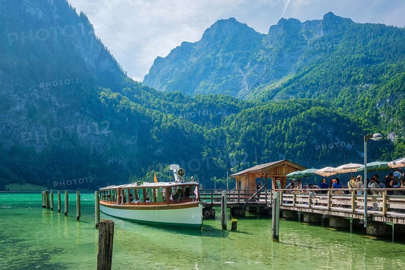 Tourist passenger boat at the Konigsee pier in Bavaria, Germany, with clear lake water and Berchtesgaden Alps behind