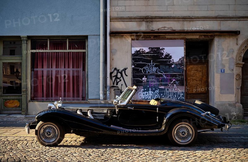 Vintage Mercedes-Benz 500 K Special Roadster 1936 (internally W29) Sindelfingen body on a wooden frame black from the side in front of a house wall with graffiti Luther city Wittenberg, Saxony-Anhalt, Germany