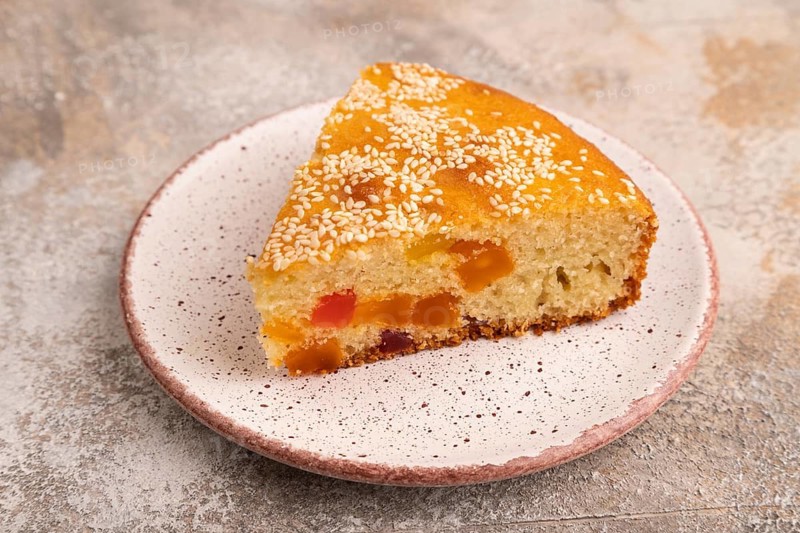 Pie with candied fruit, on brown concrete background, close up, side view