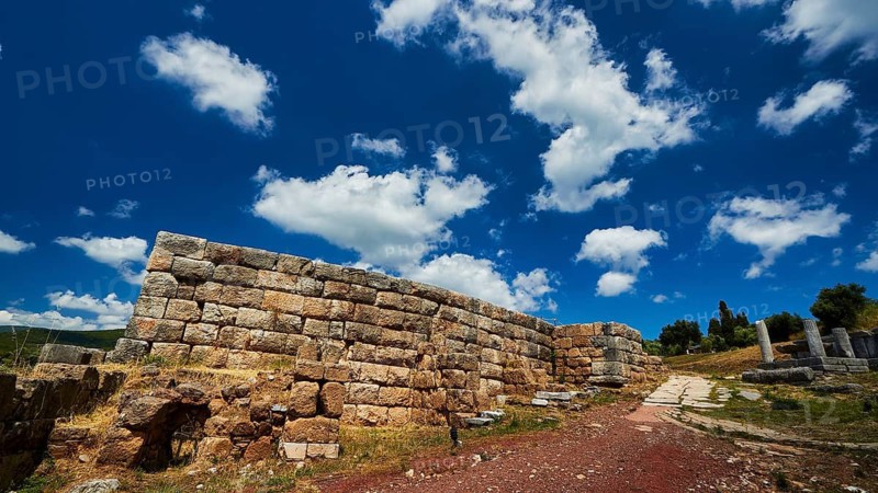 Stone wall under blue sky with dramatic clouds, ancient site, archaeological site, Messene, Messini, Messinia, southwest of the Peloponnese, odyssey, Odyssey, Odysseus, Ulysses, film, filming location, Matt Damon, Peloponnese, peninsula, Greece