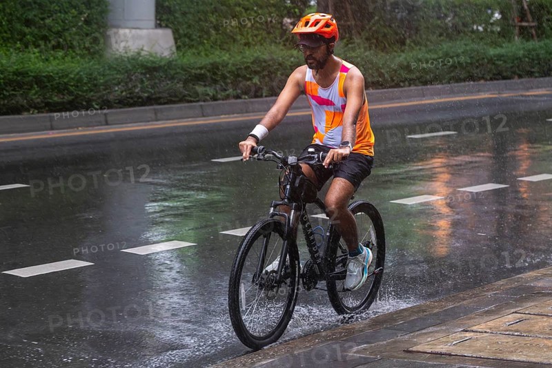Cyclists in rain, Bangkok, Thailand