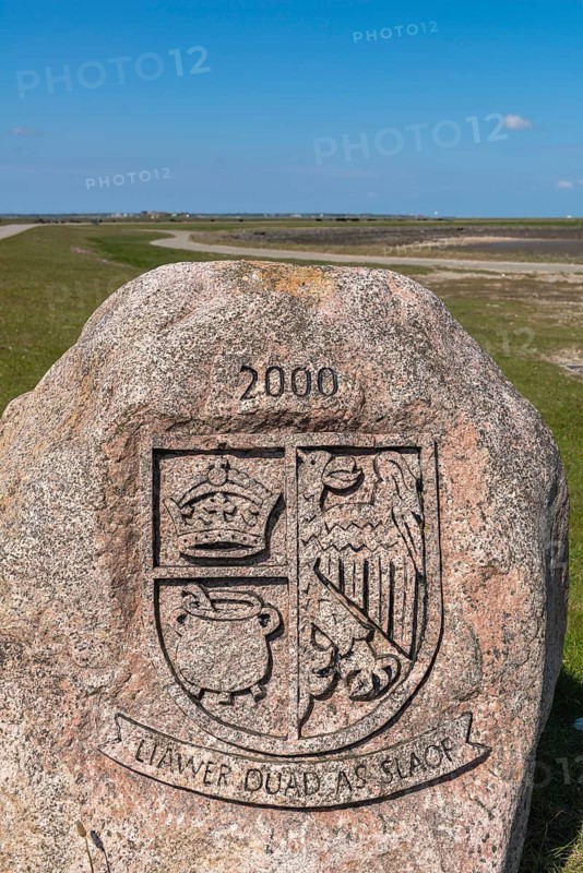 Hallig Langeneß, Schleswig-Holstein Wadden Sea National Park, boulder with Frisian motto, Liawer Duad As Slaof, Dear Dead as Slave, North Frisian coat of arms with crown, grit pot and half eagle, Halligen biosphere, North Frisia, blue sky, Schleswig-Holstein, Germany