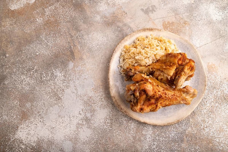 Fried Turkey Wing with spices and rice on brown concrete background. top view, flat lay, copy space
