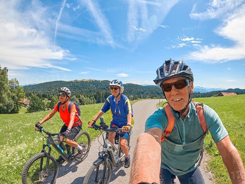 Group of active senior friends having fun during a cycling tour in the Allgau Alps near Oberstaufen, Bavaria, Germany