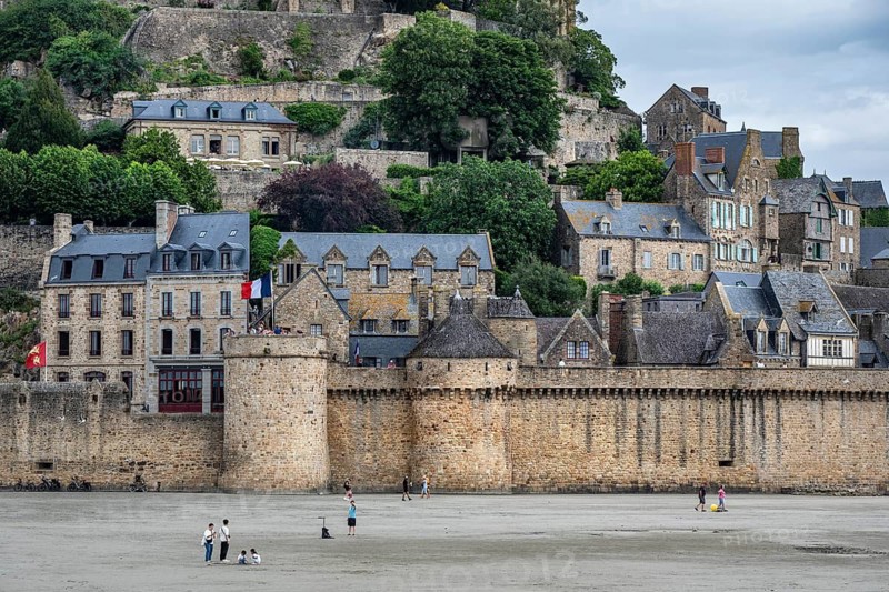 Southeast fortification walls and residential buildings, detailed view of the historic monastery island of Le Mont Saint Michel at low tide, tourist attraction, UNESCO World Heritage Site, Pontorson, Manche department, Normandy, France