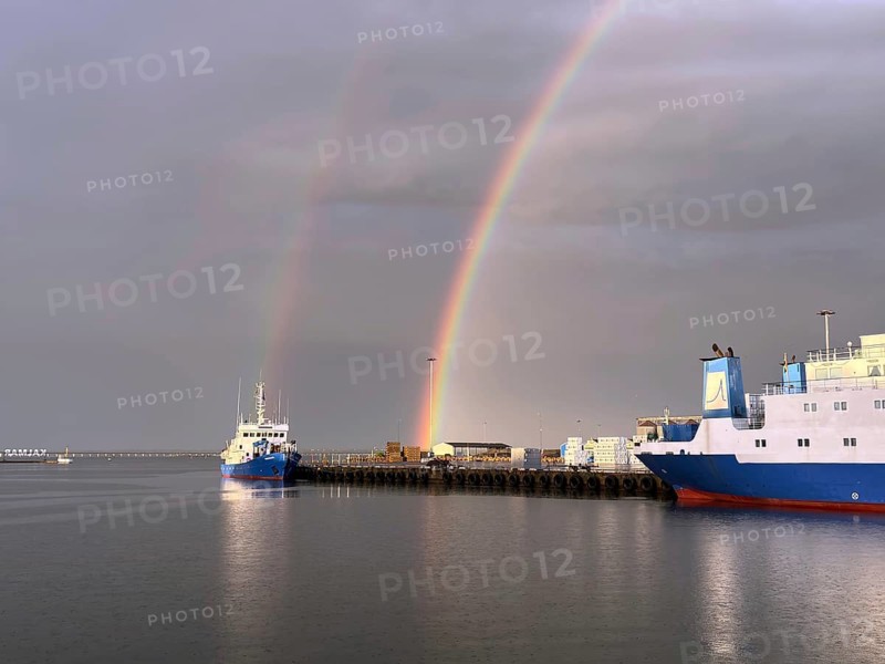 Two rainbows over a quiet harbor with several ships and cloudy sky, Kalmar, Kalmar Län, Sweden