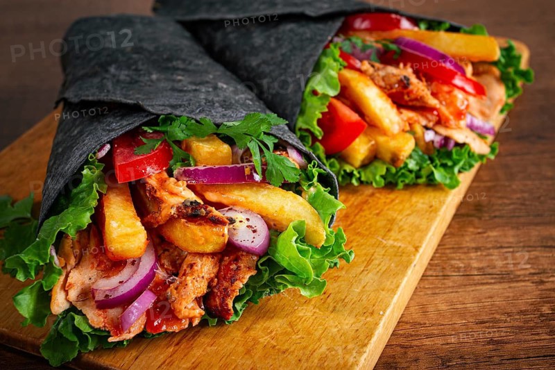 Shawarma in black lavash, on a wooden background, chicken shawarma, no people