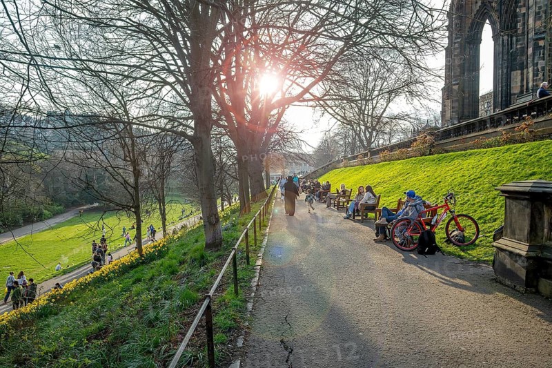 Residents sunning in spring at the Princes Street Gardens, public park in the city centre of Edinburgh, Scotland, UK