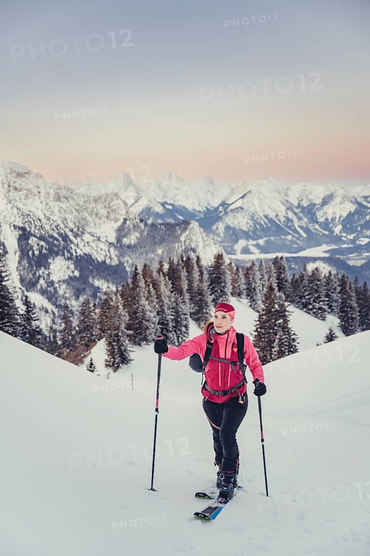 A woman's ski tour at sunrise on the Tegelberg in the Allgäu in the Ammergebirge, Bavaria, Germany