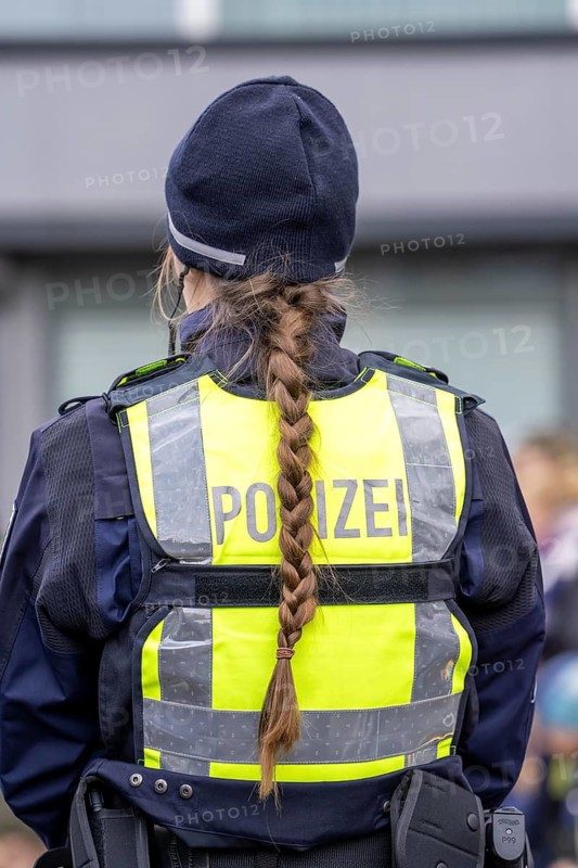 Rose Monday procession in Düsseldorf, emergency services, secure, accompany the move, policewoman with bouquets of flowers, Strüsschen, in some cases heavy rain, North Rhine-Westphalia, Germany