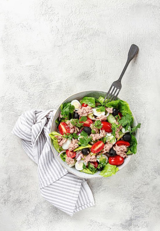 Salad with canned tuna, vegetable salad with quail eggs, lettuce and romaine leaves, red onion, cherry tomatoes, olives, keto food, healthy eating