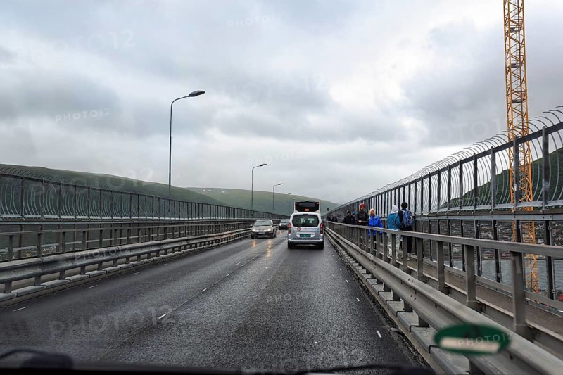 Car and passers-by on a bridge looking through a windshield in rainy weather, Tromso, Troms og Finnmark province, Norway