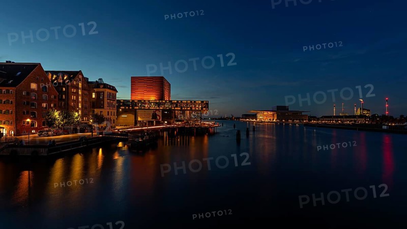 Abendstimmung in einer Stadt mit beleuchteten Gebäuden, die sich im Wasser spiegeln, Kopenhagen, Dänemark, Oper