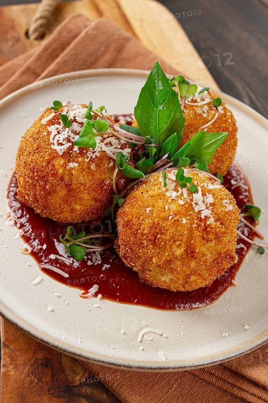 Crispy Arancini appetizer, with parmesan cheese and microgreens, plate, tomato sauce, homemade, no people