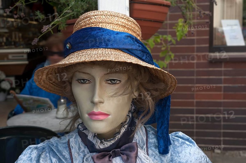 Figure wearing straw hat and nostalgic dress in front of a café, Görllitz, Upper Lusatia, Saxony, Germany