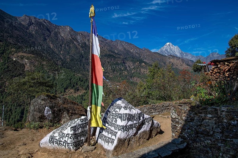 Buddhist prayer flag and holy mantras on manistones on the way to Mount Everest, Solu Khumbu, Himalayas, Nepal