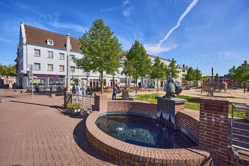 Klever Schüsterken, Spittmänneken, fountain, sculptor Jupp Brüx, general architecture, residential and commercial buildings, street, sidewalk, playground, trees, pedestrians as a secondary motif, blue sky, cirrus clouds, Opschlag junction with Herzogstraße, Kleve district, North Rhine-Westphalia, Germany