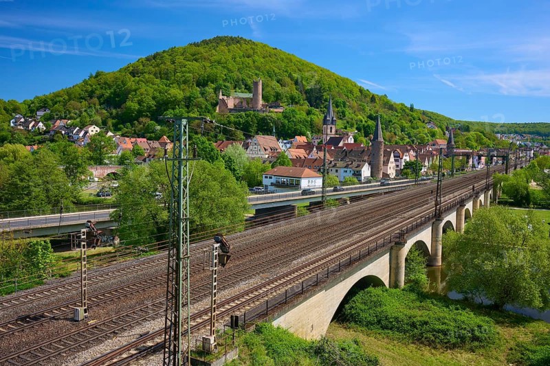 Town with a railway line on a bridge next to lush green countryside, Gemünden am Main, Main-Spessart district, Spessart, Mainfranken, Lower Franconia, Bavaria, Germany