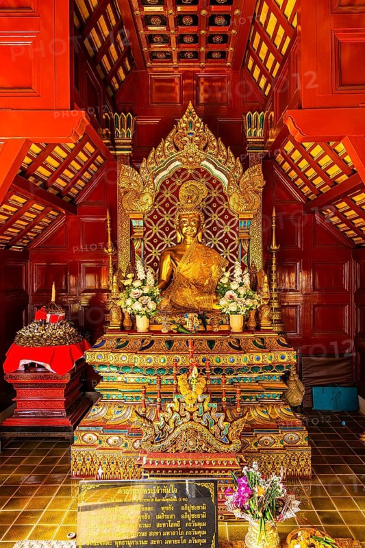 Gilded Buddha statue in a public prayer hall in the Wat Phra Singh Buddhist temple complex, Chiang Mai Old City Center, Chiang Mai Province, Thailand