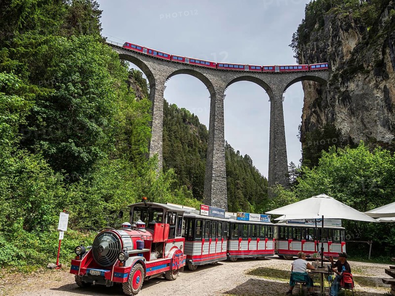 Tourist sightseeing train stops at the Landwasser viaduct, real train of the Rhaetian railroad line passing the Landwasser Viaduct, Switzerland