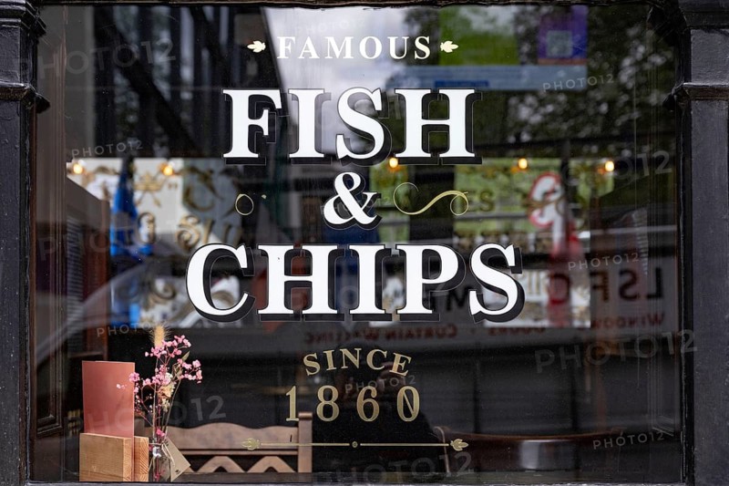 A British pub window advertising Fish and Chips the most famous English dish found all over the UK