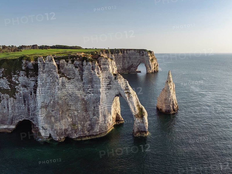 Aerial view of the Porte d'Aval rock formation in the evening sun, well-known sights on the chalk coast with the distinctive rock needle, behind it the La Manneporte rock formation, right on the cliffs of the Golf d'Étretat golf course founded in 1908, Alabaster Coast, La Côte d'Albâtre, chalk cliffs, English Channel, Seine-Maritime, Normandy, France