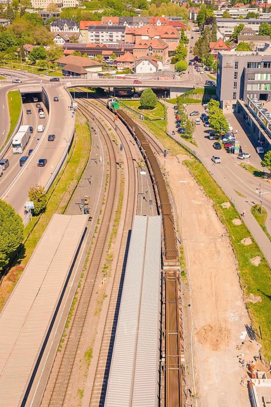 Aerial view of a train station with several train tracks and roads, surrounded by buildings and green landscape on a sunny day, electrification of the Hochrheinbahn, conversion of the station, Waldshut, Tiengen, Germany