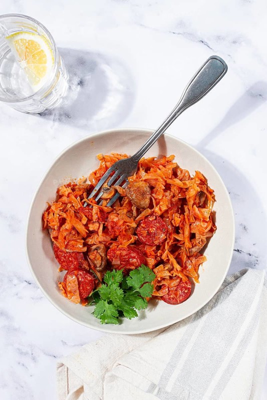 Bigos, Polish dish bigos, on a marble table, stewed meat with cabbage, chorizo sausages, mushrooms, homemade, without people
