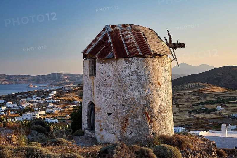 Windmill above Chorio on Mount Xaplovouni, abandoned mill on a hill with sea view at sunset, main town on Kimolos, Kimolos, Chorio, Kimolos island, neighboring island of Milos, Cyclades, Greek Islands, Greece
