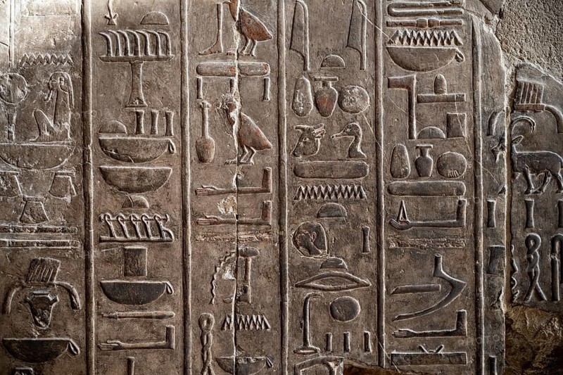 A closeup detail shot of stone carvings of Egyptian hieroglyphs in the Temple of Hatshepsut, Luxor. Egypt