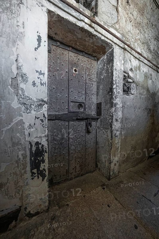 Massive aged iron door in a rough stone wall, Kilmainham Gaol Prison, Dublin, Ireland