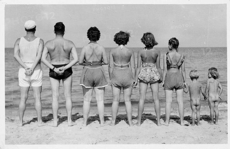 Kühlungsborn, Baltic Sea, A group of people standing on the beach wearing swimwear with their backs to the observer and looking at the sea, 1955