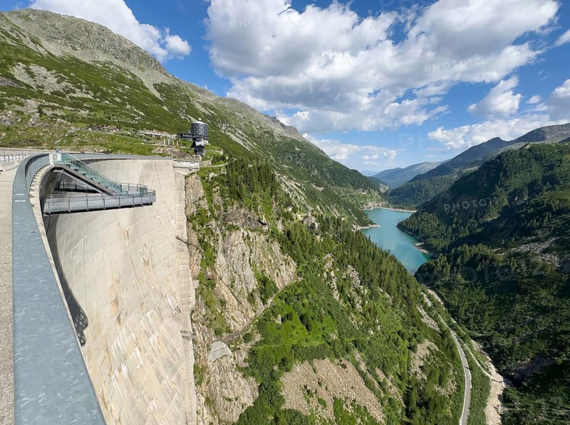View of Kölnbrein Reservoir on air side of dam wall facing away from the water with floating viewing platform Airwalk on the left, behind it modern mountain hotel Malta in the background, Galgenbichl Reservoir on the right, Malta Valley, Carinthia, Austria