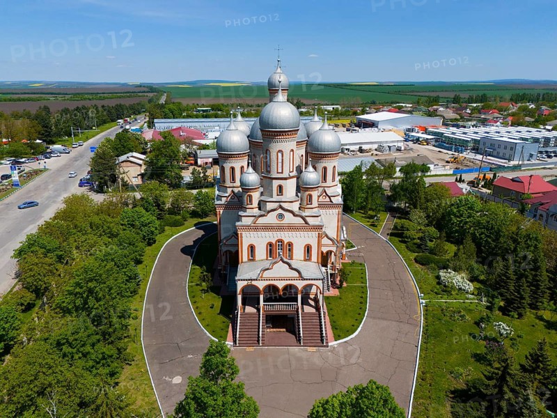 Orthodox church with large silver domes surrounded by fields and buildings in a rural area, aerial view, Ascension Cathedral, Catedrala Adormirea Maicii Domnului, Drochia, Republic of Moldova, Moldova