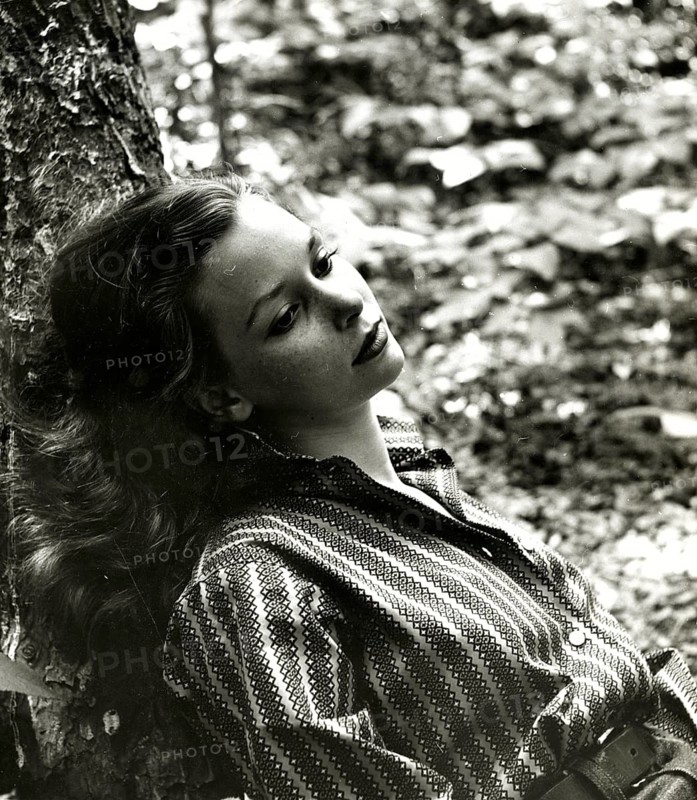 Dreamy, dream, memory, longing, melancholy, sadness, youth, thoughtful woman leaning against a tree in the forest in a melancholy portrait, around 1955