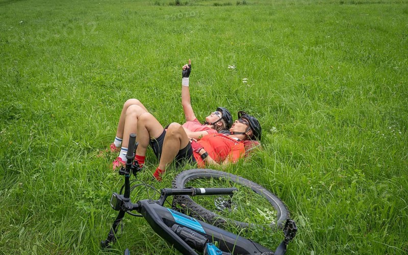 Grandmother and granddaughter having a break in a green meadow during a mountain bike tour in upper Frankonia, Hilpoltstein, Bavaria, Germany