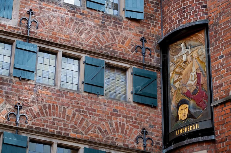 Three times a day, the carillon rings out in the historic Böttcherstrasse, a panel depicting figures between the Carillon House and the Roselius House (left), Charles Lindbergh (1902–1974), first solo transatlantic flight, the old town of the Hanseatic city of Bremen from the 1920s, an example of Klinker Expressionist architecture, artistic design, brick architecture, aeroplane, flight, shutters, a popular tourist destination, Germany