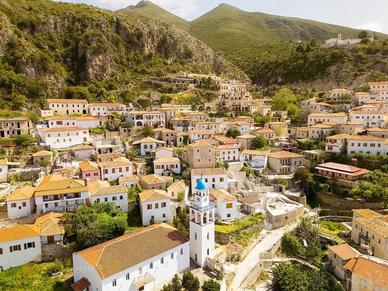Stunning aerial panorama historic Saint Mary Monastery or Kisha e Shen Merise perched atop the old village of Dhermi, overlooking traditional Dhermi stone houses