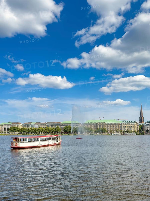 The Alsterdampfer Eilbek (fully electric) on the Inner Alster Lake, with the Alster Fountain, Hamburg city centre and the tower of St Petri's Church in the background, Hamburg, Germany