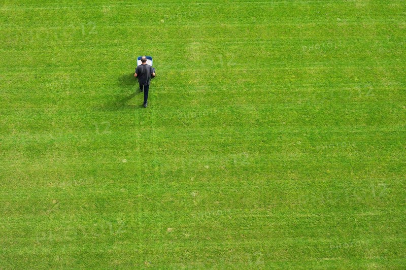Groundsman spreads artificial fertilizer for grass on a football pitch in Lubin, Poland