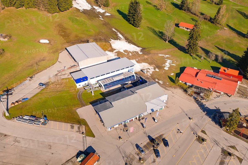 An industrial complex with parking spaces in a rural area with fields, Allgäu, Bavaria, Germany