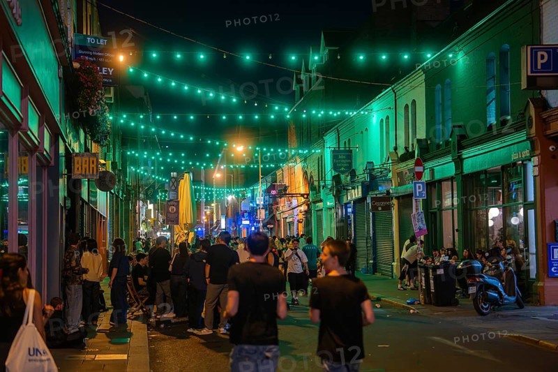 Street full of people under green fairy lights, reflecting the lively nightlife, nightlife, Dublin, Ireland