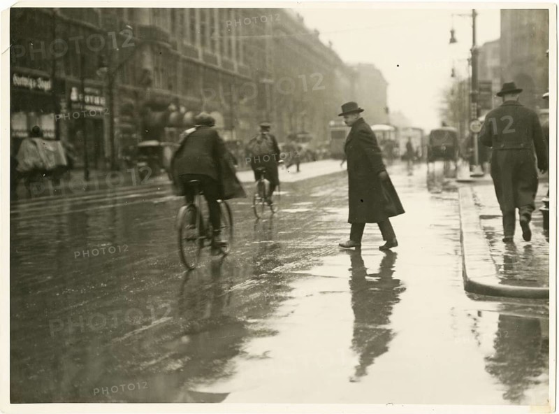 Berlin, Mitte, Leipziger Straße, snapshot, street scene, traffic, man in a coat crossing a city street when it rains, cyclist, twenties, Sasha Stone, around 1928