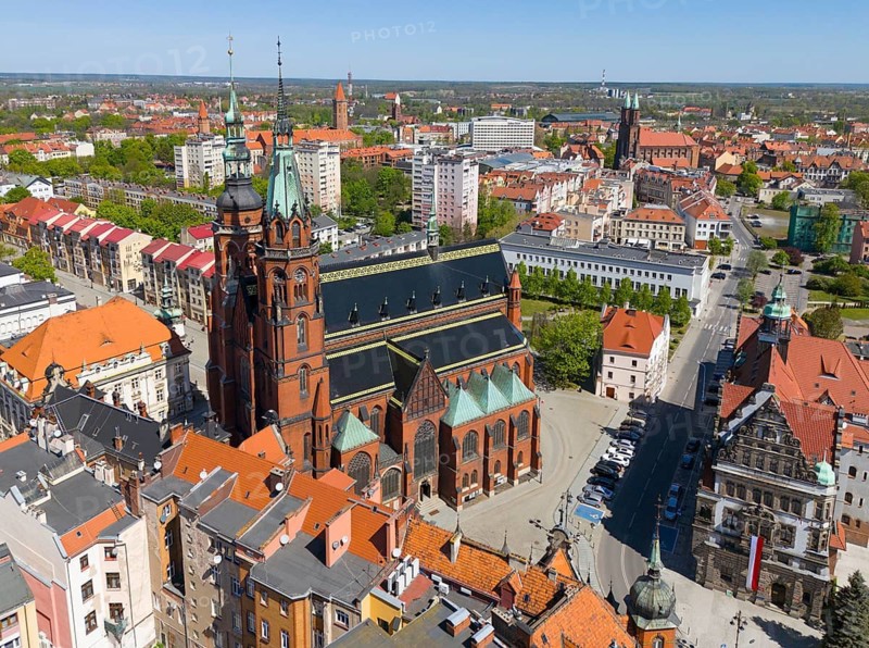 Church with tall towers in an urban environment surrounded by buildings with red tiled roofs, aerial view, St. Peter and Paul Cathedral and City Hall, Legnica, Liegnitz, Lower Silesia Voivodeship, Poland