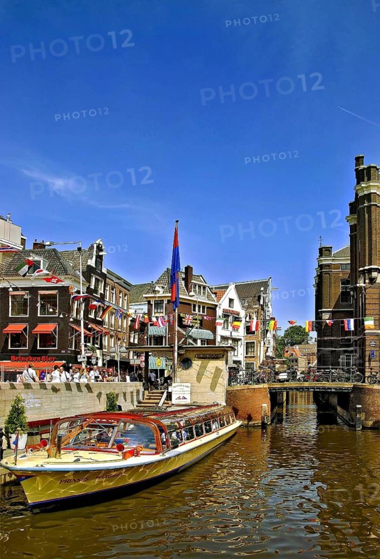 An excursion boat with tourists in a canal in the city of Amsterdam, the Netherlands, Holland