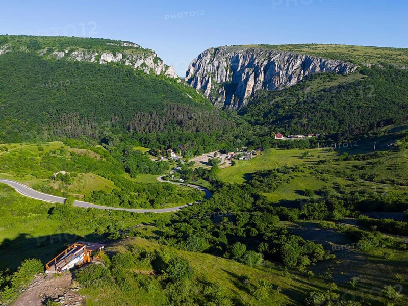 A picturesque landscape with green hills, a small village and impressive cliffs in the background, aerial view, Cheile Turzii, Turda Gorge, Thorenburg Gorge, Turda, limestone gorge in the Trascau Mountains, Trascau, nature reserve, Western Carpathians, Transylvania, Romania