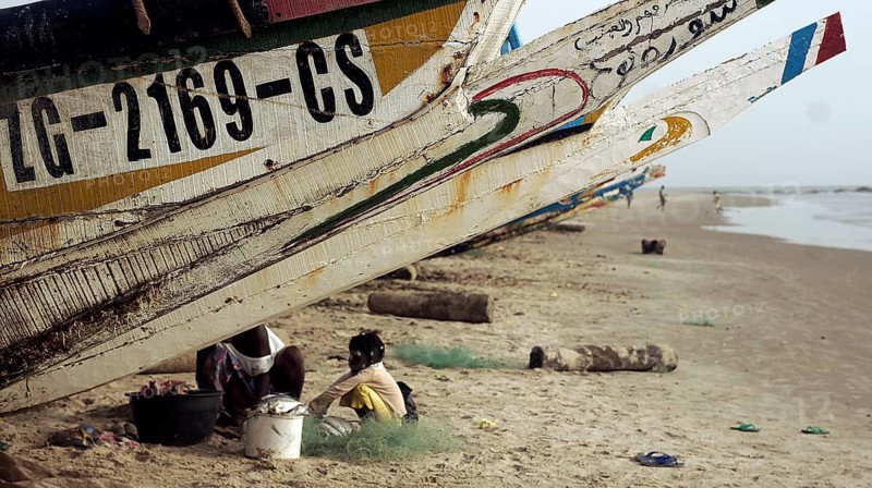 Fishing boats with people working on a sunny day, Cap Skirring, Casamance, Senegal