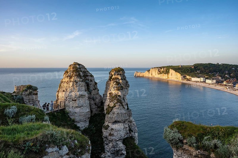 Distinctive rock formation and landmark Chambre des Demoiselles with a bridge over a crevice on the chalk cliffs of the Falaise d'Aval rock formation near Étretat with a view of the opposite Falaise d'Amont rock formation and the Notre Dame de la Garde chapel above, Alabaster Coast, La Côte d'Albâtre, Chalk Cliffs, English Channel, Seine-Maritime, Normandy, France